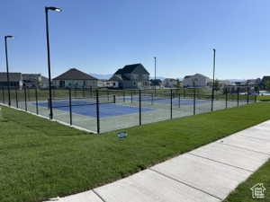 View of tennis court with a residential view