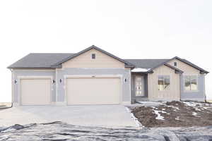 View of front of home featuring driveway, a garage, roof with shingles, and board and batten siding