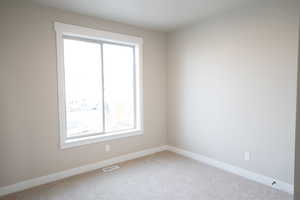 Unfurnished room with baseboards and carpet