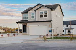 View of front of house featuring board and batten siding, concrete driveway, an attached garage, and roof with shingles