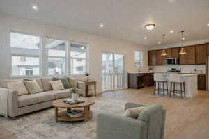 Living room with light wood-type flooring and recessed lighting