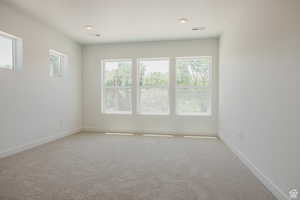 Empty room featuring light colored carpet and baseboards