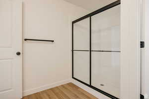 Bathroom featuring light wood-style floors and a stall shower
