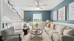 Living room featuring baseboards and ceiling fan