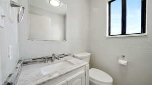 Bathroom featuring a textured wall and vanity
