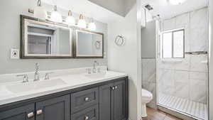 Bathroom with double vanity, a stall shower, and light tile patterned flooring
