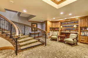 Living area with recessed lighting, crown molding, light carpet, and stairway