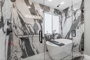 Full bathroom with stone wall, a soaking tub, a marble finish shower, tile walls, and recessed lighting