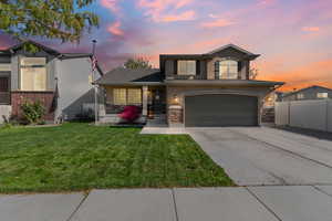 Traditional home featuring driveway, an attached garage, a porch, and stucco siding