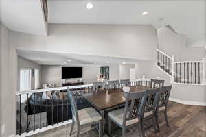 Dining area featuring recessed lighting, wood finished floors, stairway, and high vaulted ceiling