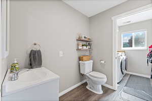 Bathroom with separate washer and dryer, wood finished floors, and vanity