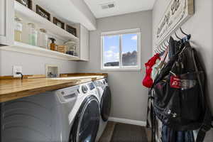 Laundry area with cabinet space, dark wood-style flooring, and washer and dryer