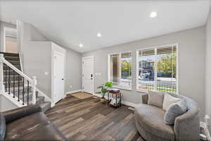 Living room featuring stairs, recessed lighting, and dark wood-style floors