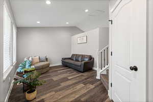 Living room featuring recessed lighting, dark wood finished floors, and lofted ceiling