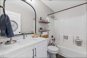 Bathroom with bathing tub / shower combination, vanity, and a textured ceiling