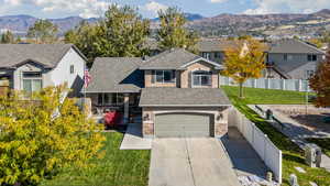 Traditional-style house featuring roof with shingles, a mountain view, driveway, and stone siding
