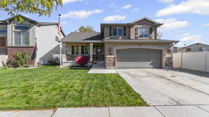 Traditional-style home with covered porch, driveway, stucco siding, and a garage