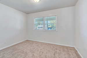 Carpeted empty room featuring baseboards
