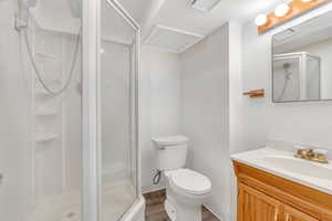 Bathroom featuring vanity, a stall shower, and light wood-type flooring