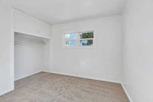 Unfurnished bedroom featuring light colored carpet and a closet