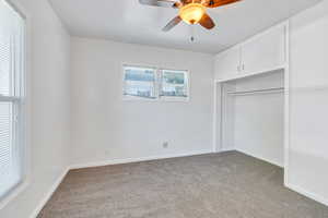 Unfurnished bedroom featuring light carpet, ceiling fan, and a closet