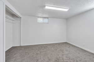 Basement featuring a textured ceiling and carpet