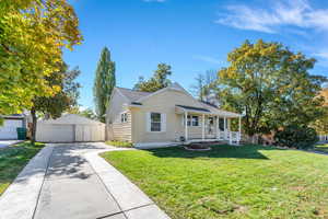 Bungalow featuring an outbuilding, a front yard, a garage, and covered porch
