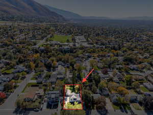 Aerial perspective of suburban area with property parcel outlined and mountains
