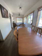 Dining area with dark wood-type flooring, plenty of natural light, and a ceiling fan