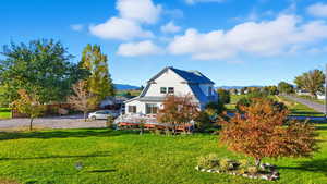 View of property exterior featuring a lawn and a metal roof
