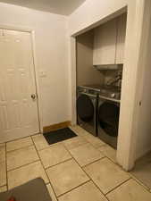 Washroom featuring light tile patterned floors and washer and clothes dryer