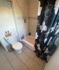 Full bath with tile patterned flooring and shower / bath combo