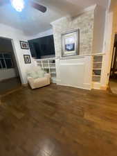 Living area featuring dark wood-style floors and ceiling fan