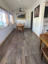 Dining area with dark wood-style flooring and baseboards