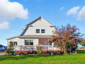 View of front of house featuring a front lawn and a wooden deck