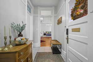 Doorway to outside featuring a chandelier and baseboards
