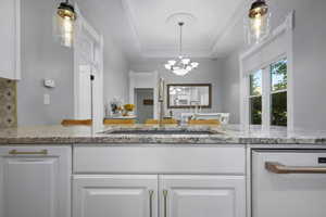 Kitchen with light stone counters and white cabinetry