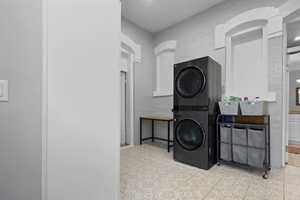 Laundry room with stacked washing machine and dryer