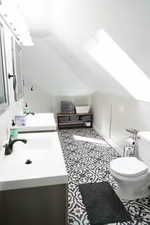 Half bathroom with vanity and lofted ceiling