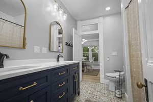 Bathroom with a shower with shower curtain, double vanity, recessed lighting, and a chandelier
