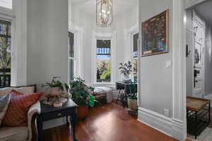 Hall featuring wood finished floors and a chandelier