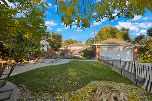Fenced backyard featuring a garage and an outdoor structure