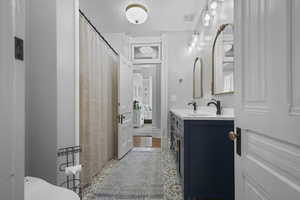 Bathroom with double vanity, a shower with shower curtain, and wood finished floors