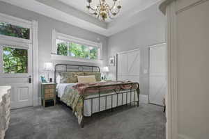 Bedroom with dark colored carpet and a chandelier