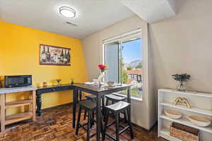Dining room featuring a textured ceiling and baseboards
