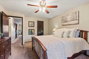 Bedroom featuring carpet floors, a textured ceiling, and ceiling fan