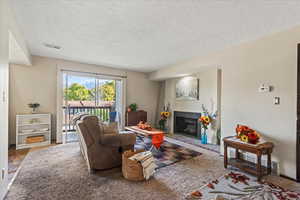 Living area featuring a textured ceiling and a fireplace