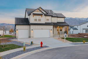 Modern inspired farmhouse with board and batten siding, a mountain view, covered porch, and roof with shingles