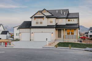 Modern inspired farmhouse featuring a mountain view, covered porch, a shingled roof, and driveway