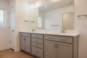 Full bathroom featuring double vanity, light wood-style flooring, and recessed lighting